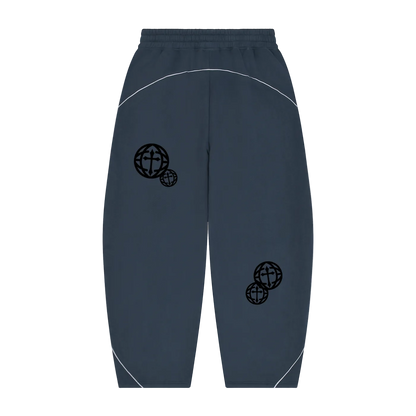 A pair of dark slate blue sweatpants with black globe graphics on the thighs and white contrast stitching, shown against a plain white background.
