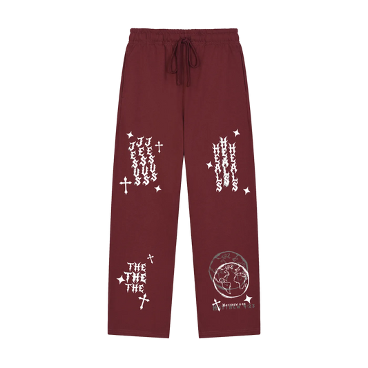 A pair of maroon drawstring sweatpants with white graphic prints, including 'JESUS' and 'HESSUS' on the upper legs, 'THE THE' with a cross on one leg, and a globe graphic with 'MORTEM A LETA' on the other, shown against a plain white background.