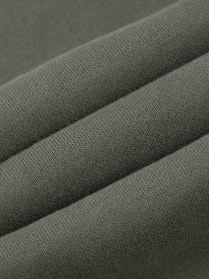 A close-up of folded olive green knit fabric showing the texture and weave.