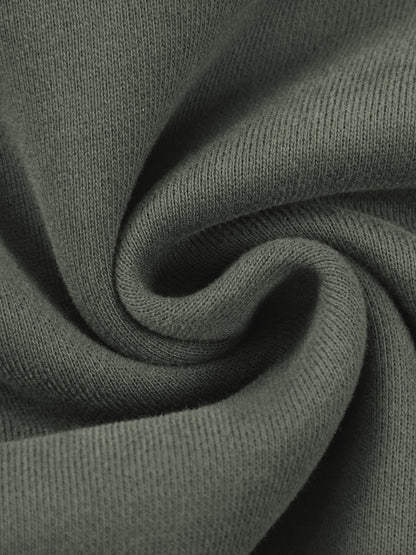 A close-up of dark olive green knit fabric with a soft, swirled texture.
